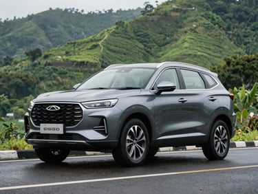 Low-angle heroic shot of Chery Tiggo 9csh in deep metallic grey, parked on a clean modern wet asphalt road in Bogor with lush green hills in the soft-focus background, natural dramatic daylight