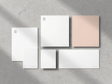 Detail of premium event stationery and minimalist branding materials arranged on a textured stone surface, soft shadows, overcast light