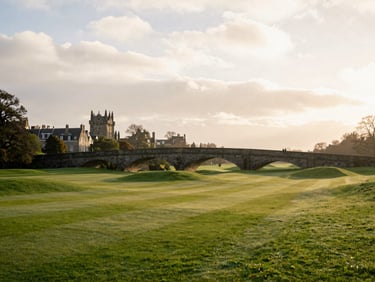The Swilcan Bridge at St Andrews under a soft overcast Scottish sky, historic stone bridge, quiet fairways, 35mm