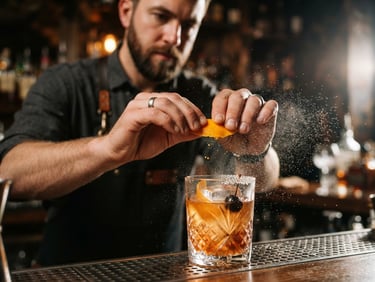 Close-up of a professional bartender expressing citrus zest over a crystal glass, microscopic mist of essential oils caught in sharp side lighting, shallow depth of field
