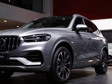Dramatic low-angle shot of a metallic silver luxury SUV, sharp reflections, modern Indian showroom background, low-key studio lighting.