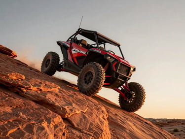 Low-angle dynamic shot of a custom red Polaris RZR perched on a steep red slickrock ledge, dramatic golden-hour rim lighting.