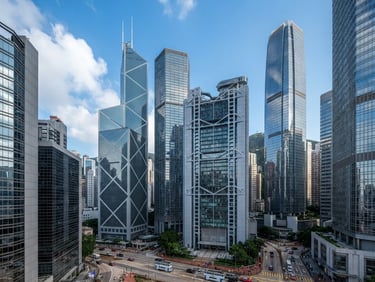 Wide-angle architectural view of Hong Kong's Central district skyscrapers in bright natural daylight, clean glass facades, cool slate and navy tones, sharp focus.