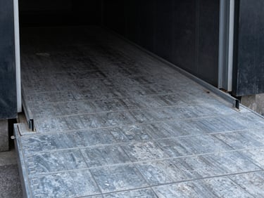 Heavy industrial loading dock ramp with structural steel reinforcement plates, cool high-contrast metallic tones, 35mm