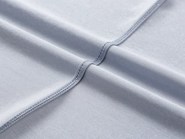 Bright studio shot of high-quality activewear fabric textures, showing precise stitching details, 35mm medium format