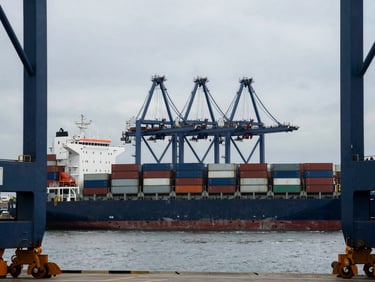 Container ship at a deep-water port, cargo cranes, global trade, cinematic, premium editorial photography, deep navy and steel tones, architectural framing, 35mm