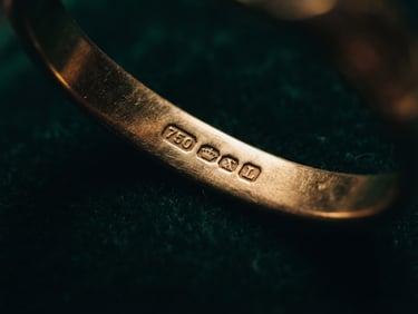 Extreme close-up of a hallmarked gold edge catching dramatic low-key directional lighting, shallow depth of field, 85mm lens