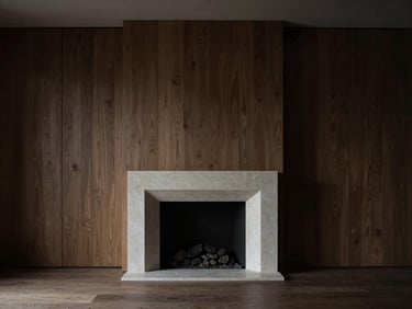 Straight-on architectural elevation of a minimalist living room, dramatic low-key natural side-light, honed Belgian bluestone fireplace, deep shadows, fumed oak paneling, monochrome styling.