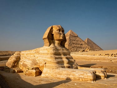 The Great Sphinx and Pyramids of Giza shot from a low angle casting long shadows in the harsh afternoon sun, warm terracotta tones.