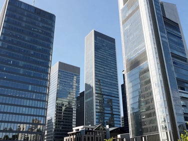 Modern architectural shot of Frankfurt's clean glass skyscrapers reflecting bright daylight, sharp focus, professional corporate travel aesthetic.