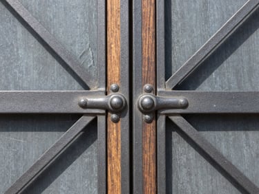 Macro detail shot of custom architectural ironwork meeting premium hardwood, straight-on symmetrical composition, sharp focus.