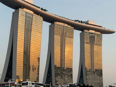Modern architectural detail of Marina Bay Sands, warm golden hour light reflecting on glass facades, sharp details, editorial photography, 35mm