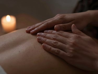 Close-up of hands applying precise pressure on a shoulder, subtle herbal compress details, soft low-key candlelight, moody editorial photography.