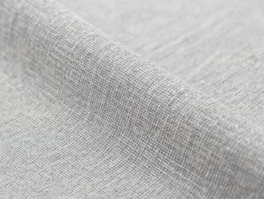 Macro close-up of premium slate gray organic cotton textile weave, bright neutral studio light, detailed fabric textures, sharp focus, high-end feel