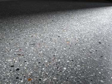 Extreme close-up of a full-broadcast epoxy flake floor, showing dense, multi-colored flakes with a high-gloss finish, dramatic side-lighting.