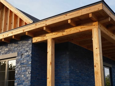 Close-up of premium timber framing and custom masonry on a modern custom home exterior, natural daylight.