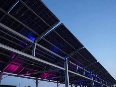 Low-angle heroic twilight shot of a massive industrial solar array on a steel carport structure, electric blue lighting accents, sharp architectural focus, 35mm lens.