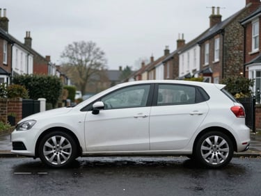 A clean used hatchback parked on a quiet wet UK residential street, soft overcast daylight, muted tones, 35mm lens