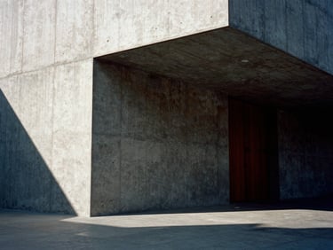 Dramatic eye-level shot of a monolithic concrete architectural model, harsh afternoon side-lighting casting deep shadows, raw concrete texture, 35mm film