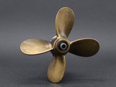 Crisp studio shot of a polished bronze marine propeller on a dark gray background, technical lighting