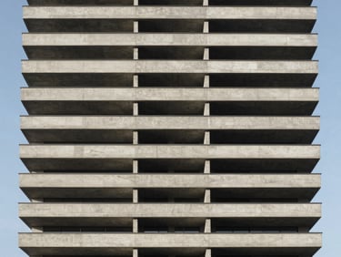Minimalist modern residential tower facade, repetitive concrete balconies, sharp shadows, clear sky.
