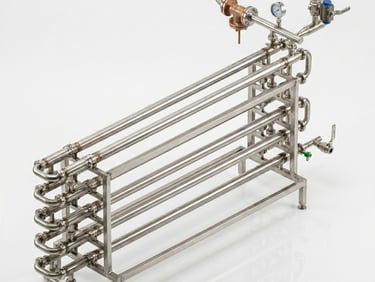 Industrial stainless steel double pipe heat exchanger with pressure gauges for thermal processing.