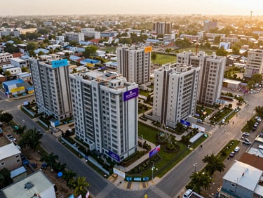 Aerial wide shot of a newly launched residential project site in Mohali Sector 105, construction hoardings visible, premium landscaping planned around the perimeter, golden afternoon light, shot from directly above at moderate altitude
