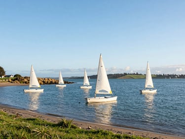 Environmental shot of small sailing dinghies moored in Christchurch Harbour, soft morning light, calm estuary waters with grassy banks.