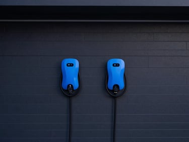 Pristine modern garage interior, dual high-output electric vehicle chargers flush-mounted on a charcoal wall, clean architectural lines, 35mm
