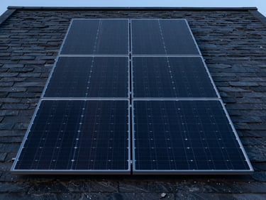 Symmetrical straight-on shot of sleek black solar panels integrated into a modern slate roof, cool twilight lighting, sharp focus