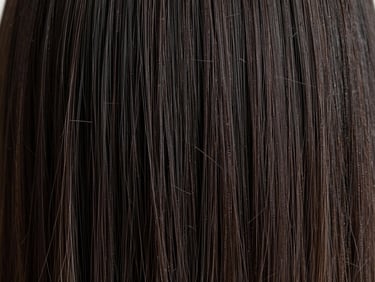 Macro shot of healthy, glossy dark hair strands under soft side daylight, emphasizing immaculate texture and structural integrity