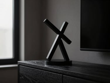 A minimalist modern living room with a matte black articulated sculpture on a dark wood mantelpiece, soft window light, deep shadows