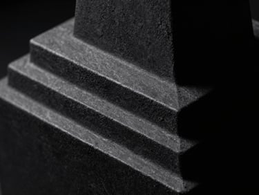 Extreme close-up of a dark graphite geometric sculpture showing intricate layers, moody chiaroscuro lighting, sharp macro focus