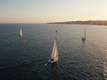 Cinematic drone shot of San Javier coast, sailing boats on calm saltwater, warm morning light.