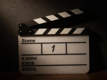 A director's clapboard with 'Scene 1' written on it, dramatic low-key lighting, deep shadows, cinematic editorial photography, high contrast