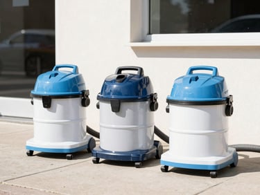Three heavy-duty industrial commercial vacuum cleaners lined up neatly on a sunny clean sidewalk outside a building, bright natural daylight, 35mm lens
