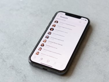 Smartphone on a marble surface displaying a guest messaging thread, overhead close-up, natural daylight, clean minimal background