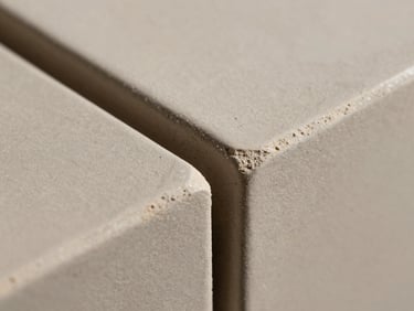 Extreme macro shot of textured architectural ceramic tiles, showing precise matte joints and raw clay texture, directional side lighting.