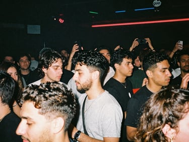 A raw, high-contrast shot of a crowded underground club dancefloor, flash photography, 35mm grain