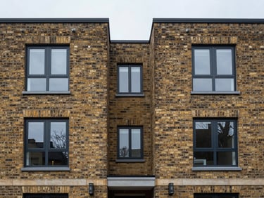 Straight-on architectural detail of a modern UK residential brick exterior, clean lines, diffuse natural daylight, symmetrical framing.