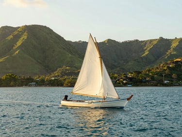A classic wooden Phinisi boat sailing on calm turquoise waters near green volcanic hills, golden hour, wide shot
