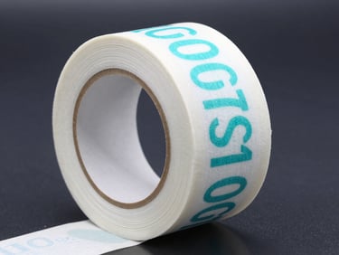 Macro shot of 100x50mm thermal label rolls on a dark metallic surface, cool cyan highlights