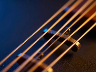 Macro close-up of golden veena strings under dramatic neon saffron and deep blue studio lighting, 35mm editorial photography