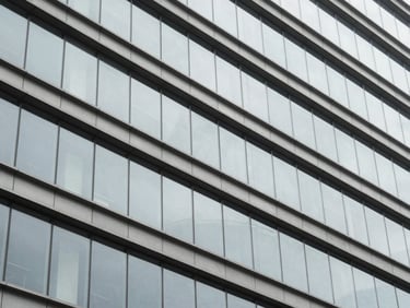 Abstract geometric pattern of architectural lines and structured glass reflecting daylight, desaturated cool tones.
