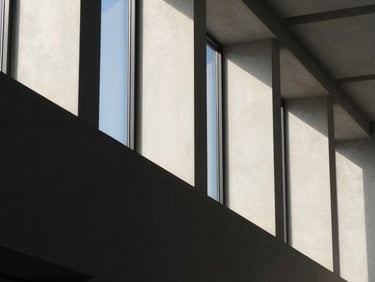 Abstract geometric concrete structure with sharp shadows, soft side lighting, elegant corporate aesthetic, 35mm lens