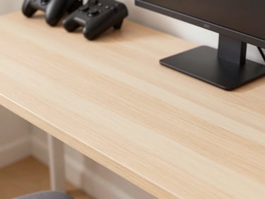 Close-up of a pastel wood gaming desk with a monitor and gaming accessories, soft daylight, clean modern styling
