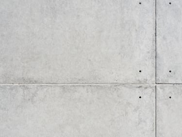 Close-up of finished smooth-set concrete wall, architectural precision, bright natural daylight, clean minimalist texture.