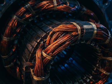 Macro shot of heavy-duty electric motor copper windings, high-contrast dramatic workshop lighting, blue and amber highlights, 35mm photography