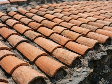 Close-up of traditional terracotta roof tiles aligned under bright Mediterranean sunlight, warm orange tones, slate background, editorial construction photography, 35mm lens