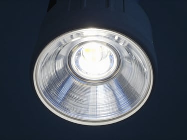 Recessed LED downlight, deep-set optics, cool high-key laboratory light, sharp metallic textures